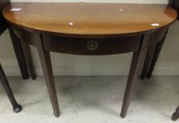 A mahogany demi-lune side table in the Sheraton taste with single drawer and square tapered legs