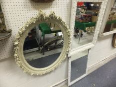A collection of four various cream painted wall mirrors - two rectangular and two oval, each with