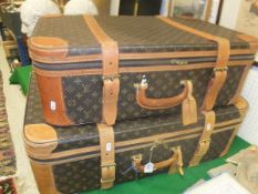 A graduated pair of Louis Vuitton style leather bound suitcases