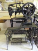 An industrial sized black painted Singer sewing machine, raised on cast metal treadle base with