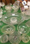 A heavily cut lead crystal glass bowl, two glass jugs, two glass candlesticks, four bowls and one