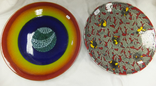 A large Poole pottery charger decorated with open magma design, together with a large Poole