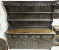 An oak dresser in the 18th Century manner, the two tier boarded plate rack over four drawers and
