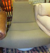 A 20th Century swivel chair of curved tapering form raised on circular base, upholstered in taupe