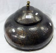 A beaten copper circular lidded pot of domed form
