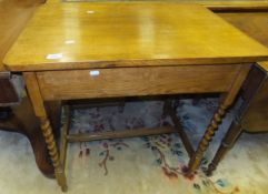 An early 20th Century oak hall table with single end drawer on barley-twist supports
