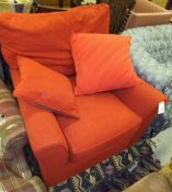A modern red upholstered armchair, together with two similar scatter cushions