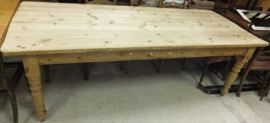 A large rectangular pine farmhouse style kitchen table on turned legs