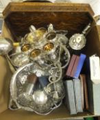 A box of assorted plated wares to include an egg cruet, various cased cutlery, swing handled basket,