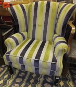A wing back scroll arm chair raised on square fluted front legs, upholstered in an oatmeal,