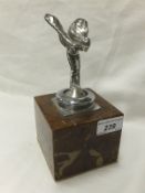 A Rolls Royce Spirit of Ecstasy car mascot mounted on a marble effect base