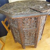 An Indian hardwood octagonal table, profusely carved with vine leaves