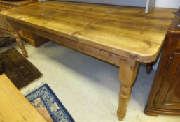 A rectangular pine kitchen table on turned and ringed legs