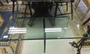A modern rectangular glass topped occasional table with glass X base