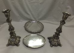 A pair of Continental white metal candlesticks in the Classical manner, together with a plated