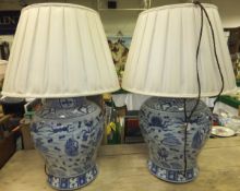 A pair of modern Chinese blue and white vases and covers as table lamps with cream coloured