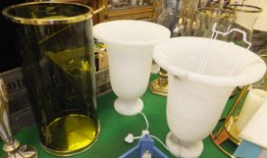 A pair of alabaster lamps and a green glass candle holder