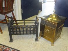 A circa 1900 brass coal box of square form raised on lion's paw feet, together with a cast iron fire