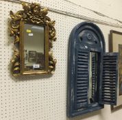 A modern gilt framed wall mirror with cherub surmount, together with a further wall mirror with