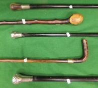 Five walking sticks / evening canes to include one with hallmarked silver handle