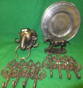 A distressed plate, eight coat hooks, cast iron retriever ornament and a ram's head door knocker*