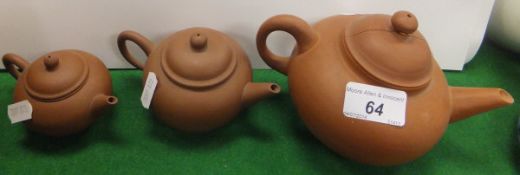 A collection of three graduated Yixing terracotta teapots and covers, each bearing impressed marks