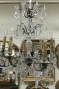 A French six branch chandelier with cut glass drops and baluster shaped glass central column