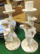 A pair of Royal Worcester porcelain figural candlesticks designed by James Hadley depicting a