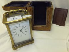 A circa 1900 French brass mounted carriage clock with Roman numerals to the dial in a brown