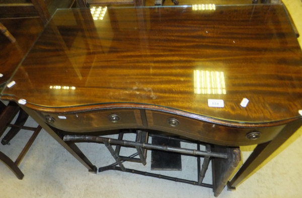 A mahogany two drawer side table with shaped front and glass top, on tapering square legs