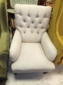 A late 19th Century upholstered button back arm chair on square tapered front legs to castors