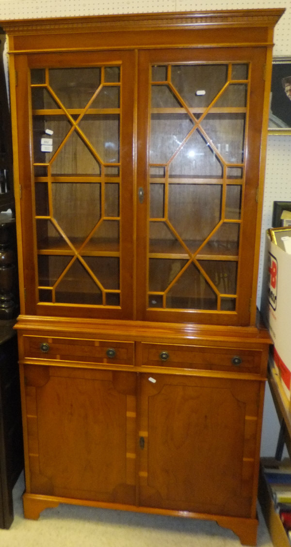 A yew veneered book case with two drawers and two cupboard doors under, and astragal glazed doors to