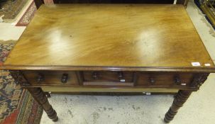 A mahogany three drawer side table with four turned legs and applied floral decoration