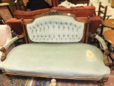 A Victorian carved walnut framed buttoned back salon sofa on turned and fluted tapering legs to