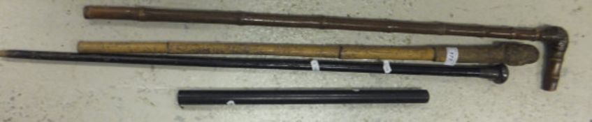 Three walking sticks, and an ebony cylindrical rule