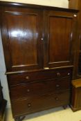 A Victorian mahogany linen press, the moulded cornice above two panelled doors enclosing two linen