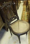 A late 19th Century walnut side chair, the pierced lyre back to a cane seat on fluted tapering legs
