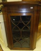 A late 19th century mahogany corner cupboard with glazed door opening to reveal various shelving