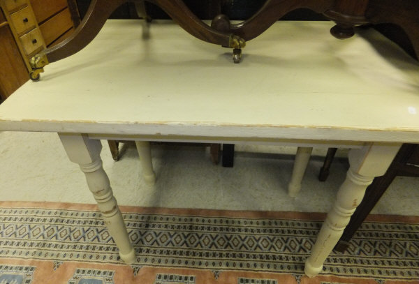 A cream painted rectangular breakfast table on turned legs