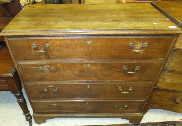 An oak chest of four graduated drawers on bracket feet