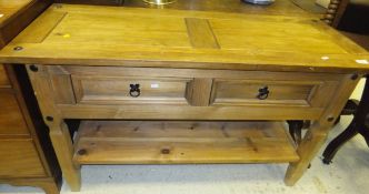 A pine and metal studded dresser base with two moulded drawers over square legs united by a platform
