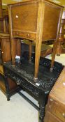 A Victorian ebonised side table with raised back over a frieze drawer, on foliate carved block