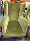 A circa 1900 upholstered wing back armchair on square tapered legs to castors