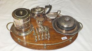 An oak and brass mounted tray together with a three piece plated tea set, toast rack, muffin dish
