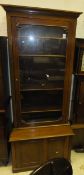 A Victorian mahogany bookcase cabinet with single glazed door and adjustable shelving over two small