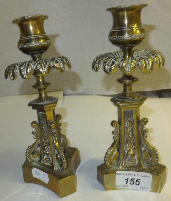 A pair of Georgian brass candlesticks with floral decoration to columns and foliate decoration to