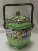 A Maling pottery lustre ware pottery biscuit barrel decorated with floral bands on a green ground