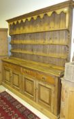 A Victorian pine dresser with enclosed back and two shelves on a base of four drawers over four