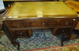 A 19th Century French walnut veneered writing table, the top with tooled and gilded leather