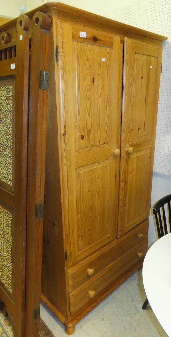 A modern two door pine wardrobe with two long drawers to the base